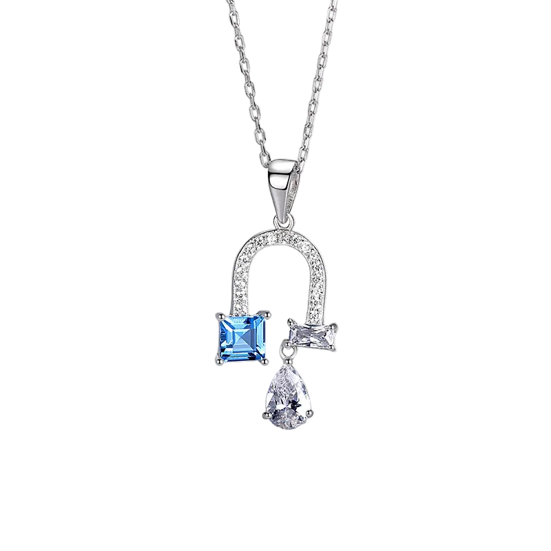 A silver pendant necklace featuring a small square blue gemstone and a teardrop-shaped clear gemstone, set on a delicate silver chain 