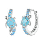 Tortoise-shaped earrings with blue accents and silver detailing on a white background