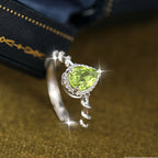 Silver ring with a green gemstone on a textured surface