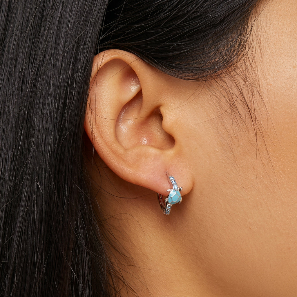 Close-up of an ear wearing a blue gemstone earring