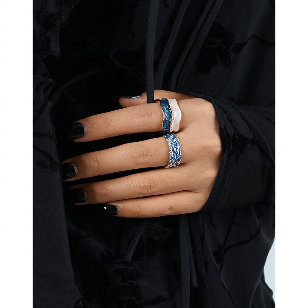 Hand wearing multiple rings with black background
