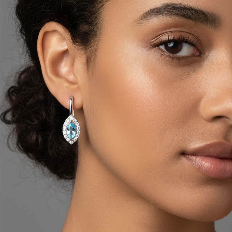 Close-up of a woman wearing a blue gemstone earring against a neutral background